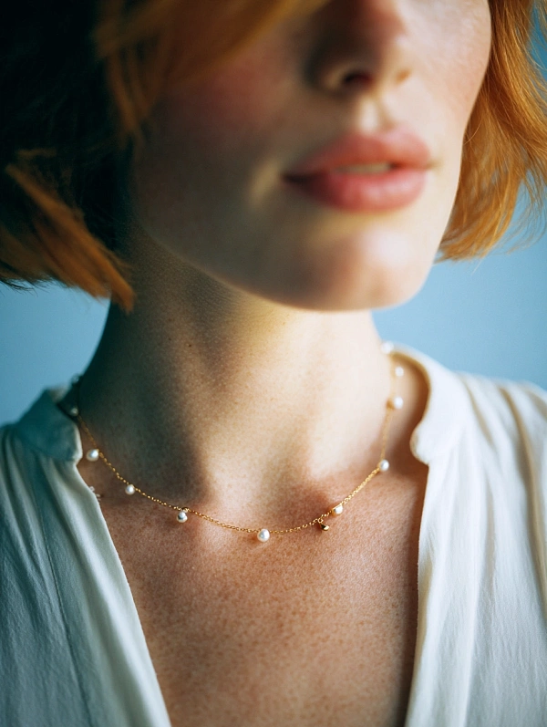 Женская шея с тонким жемчужным колье