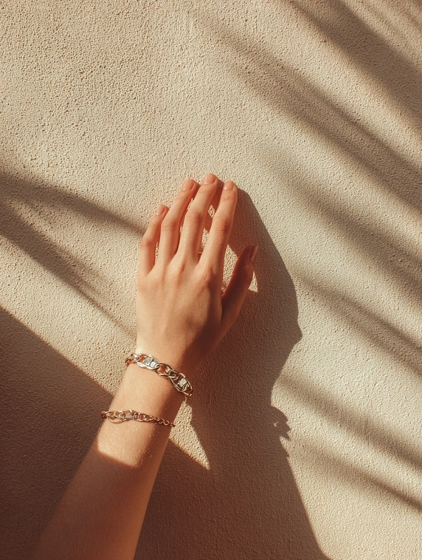 Рука с браслетами на текстурной стене